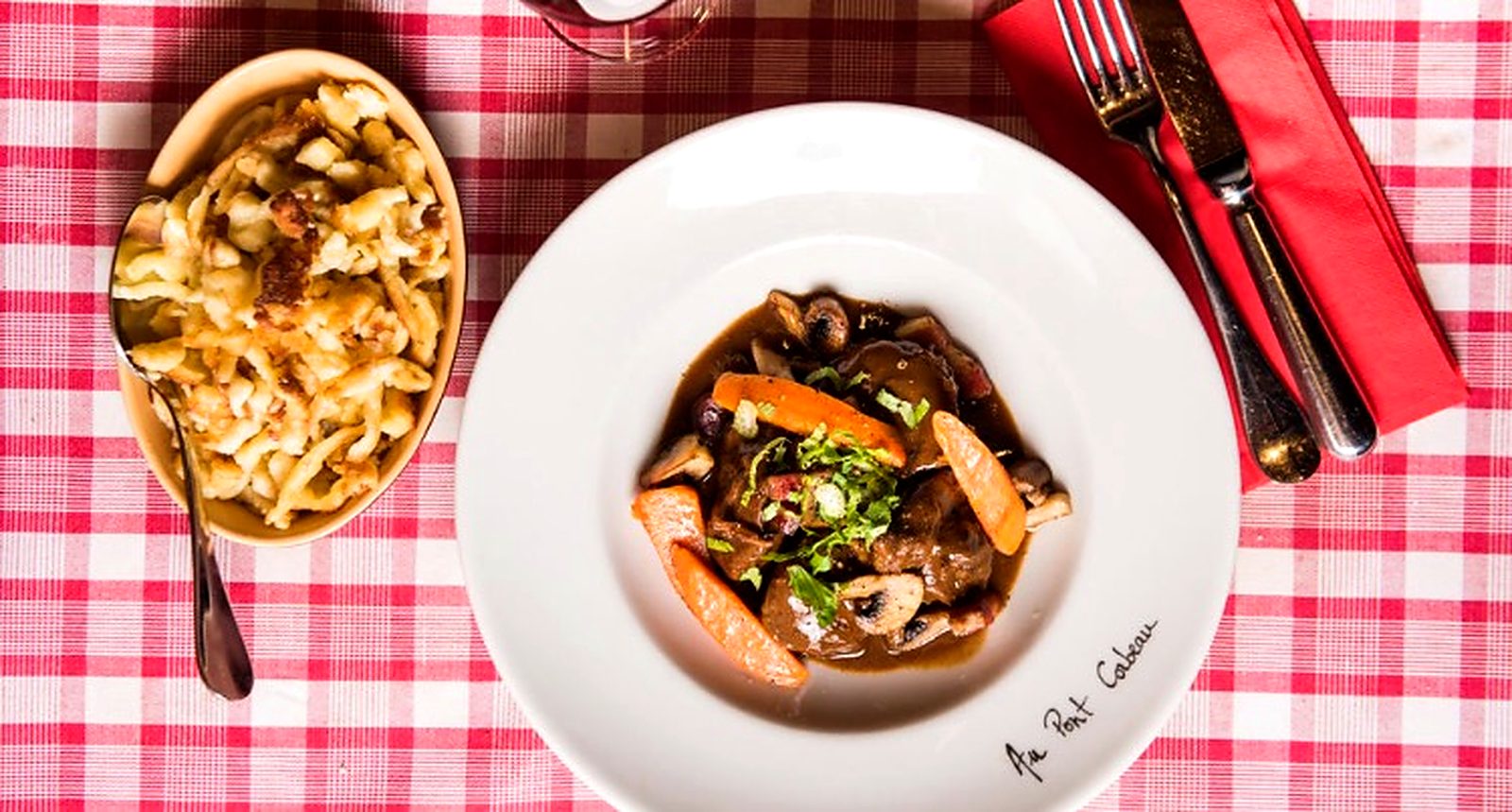 Assiette de bœuf et spätzle sur la nappe vichy, dressée à la main