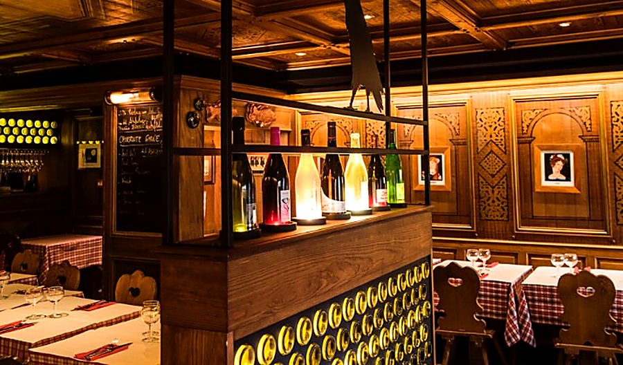 Bouteilles alignées sur le bar, devant les panneaux de bois